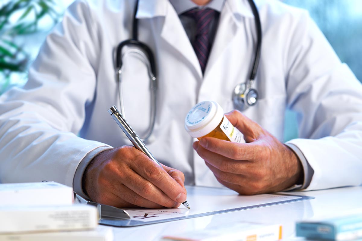 Doctor writing a prescription at his desk